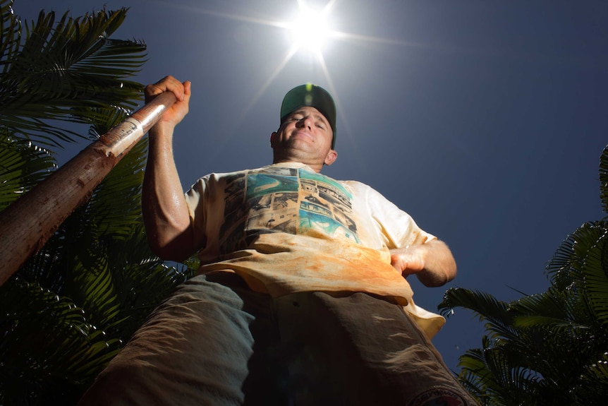 Man working outside with the sun beaming behind him.