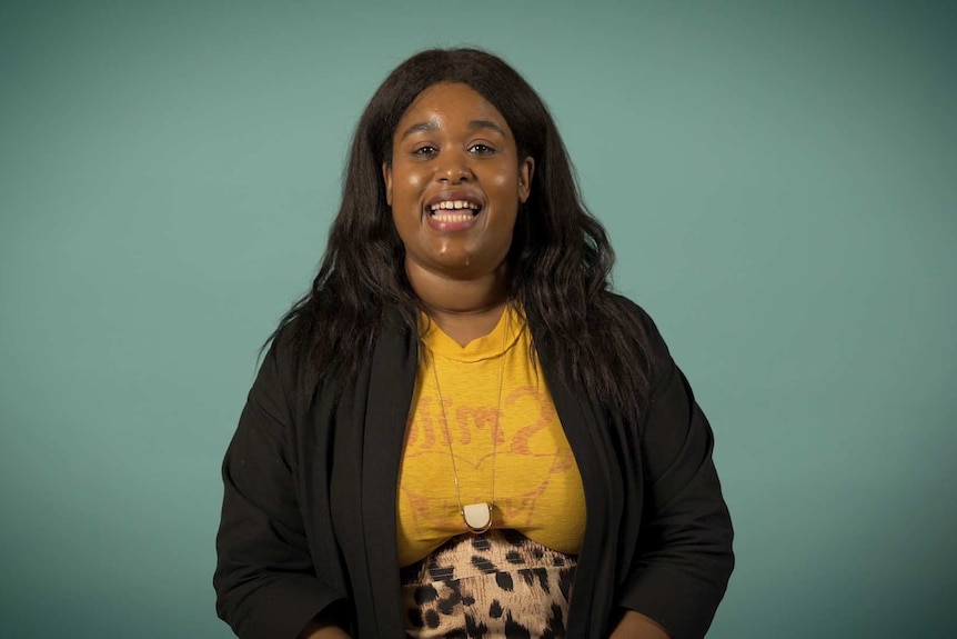 Aminatou Sow is sitting in front of a green screen and smiling