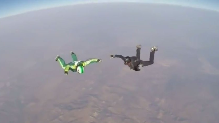 Two skydivers with no parachutes about 5,000 metres above ground, earths horizon.
