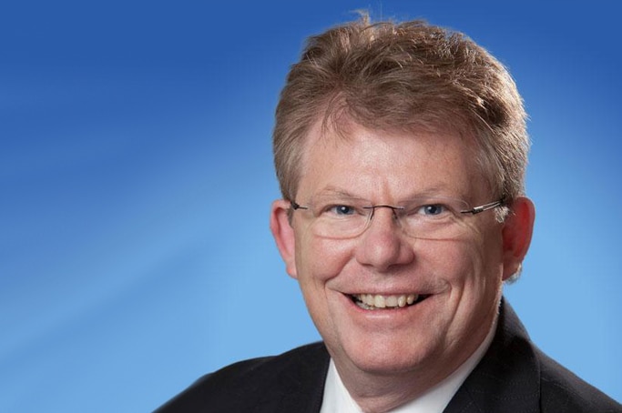 Robert Mallett headshot against blue background.