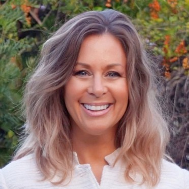 woman in white button up shirt outside smiling