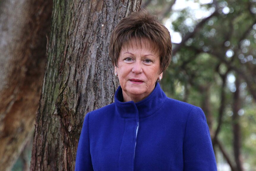 Former WA MP Andrea Mitchell stands in front of a tree.