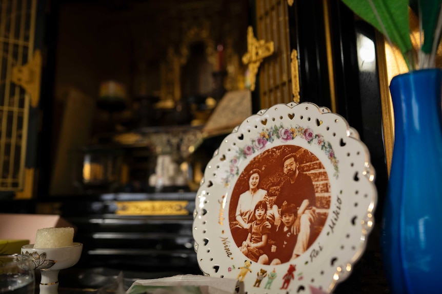 A small plate with a photo of the Miyazawa family at the centre
