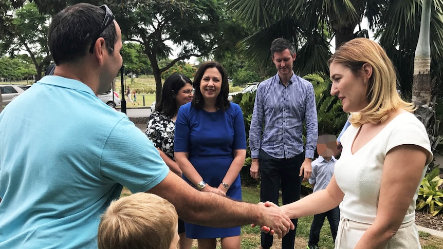 Minister Shannon Fentiman shakes a foster carer's hand as the Premier looks on