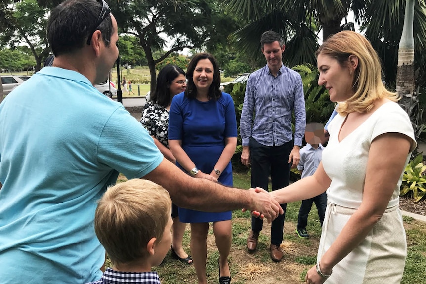 Minister Shannon Fentiman shakes a foster carer's hand as the Premier looks on