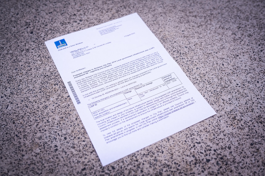 An official-looking letter on a concrete pavement.
