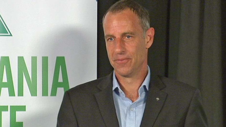 Tasmanian Greens leader Nick McKim in front of a Greens sign.