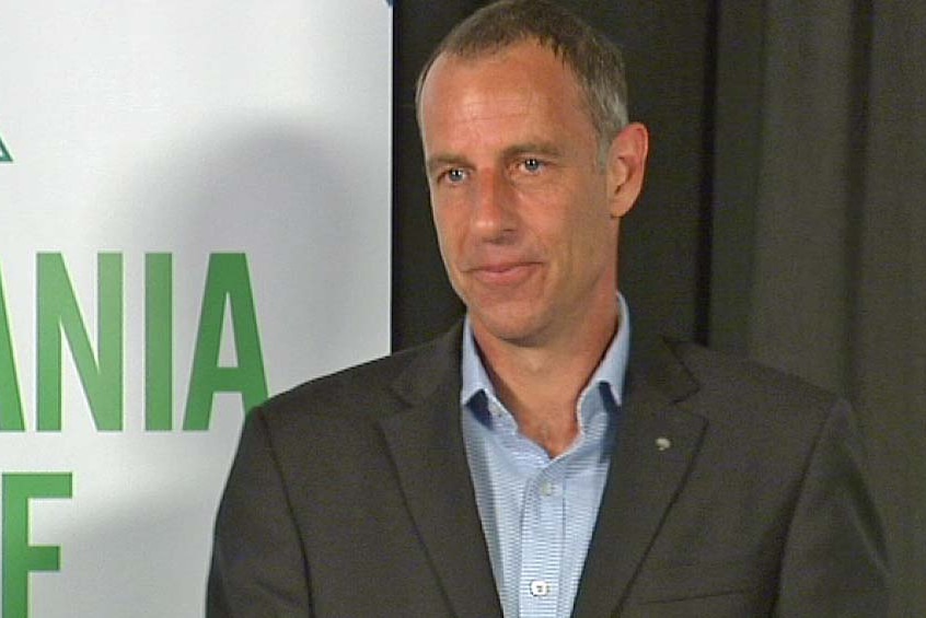 Tasmanian Greens leader Nick McKim in front of a Greens sign.
