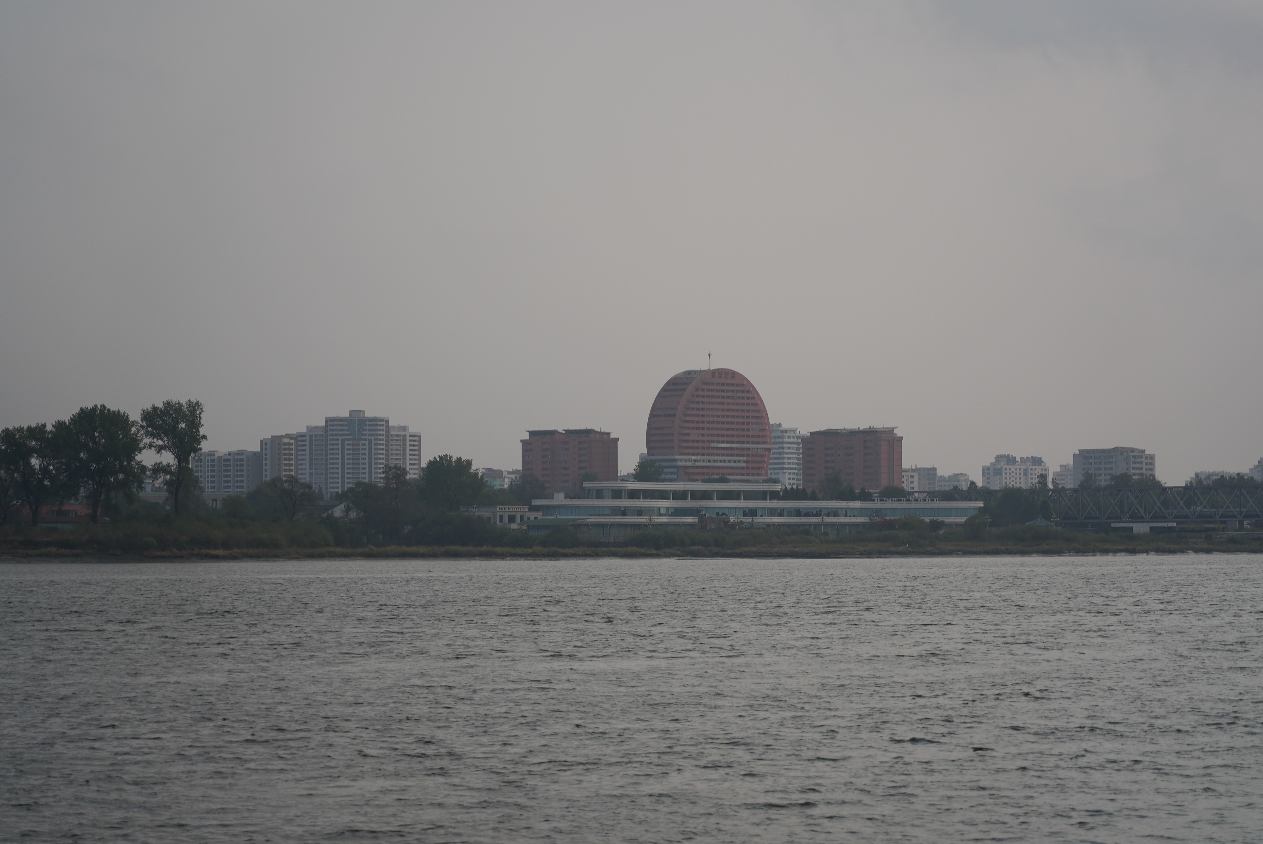 The skyline of Sinuiju seen from across a waterway.