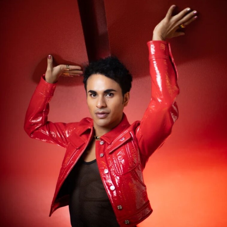 Samuel Mariño wearing a red jacket in front of a red background