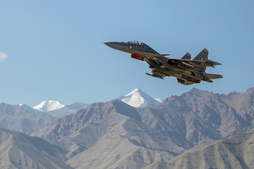 An Indian fighter plane flies over a mountain range