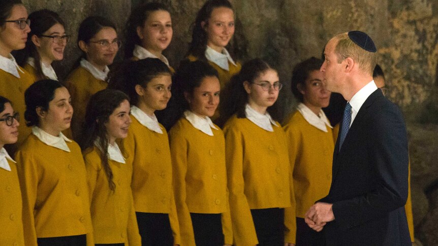 Prince William speaks to choirgirls after a ceremony in the Hall of Remembrance at the Yad Vashem Holocaust Memorial.