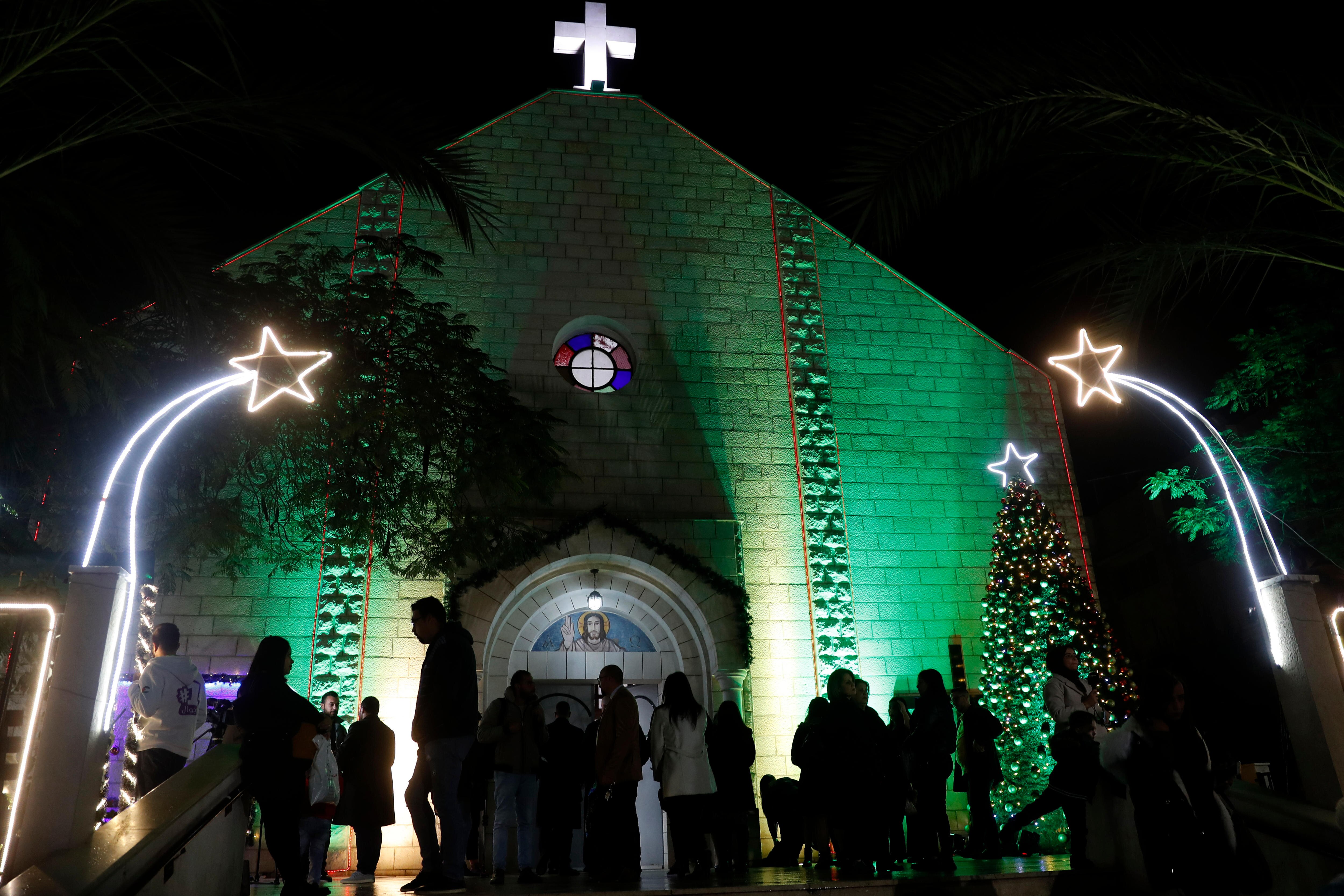 Several people wait outside in the dark in church.