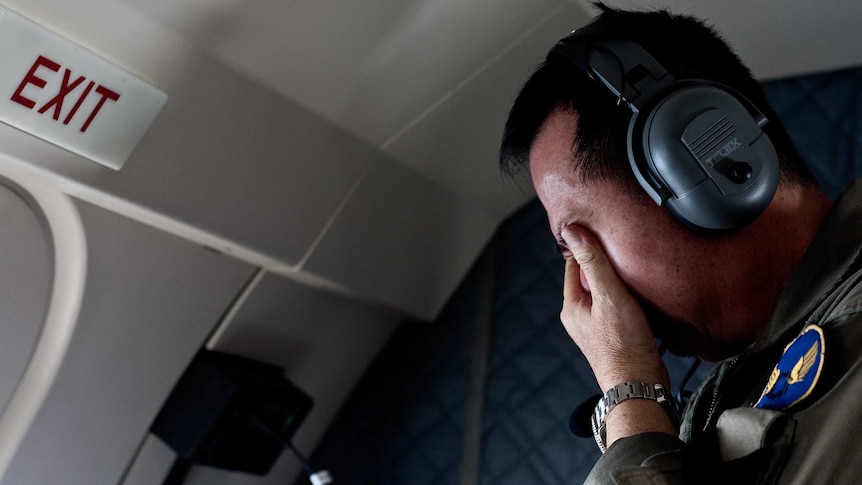 Man covers face after seeing body of AirAsia passenger