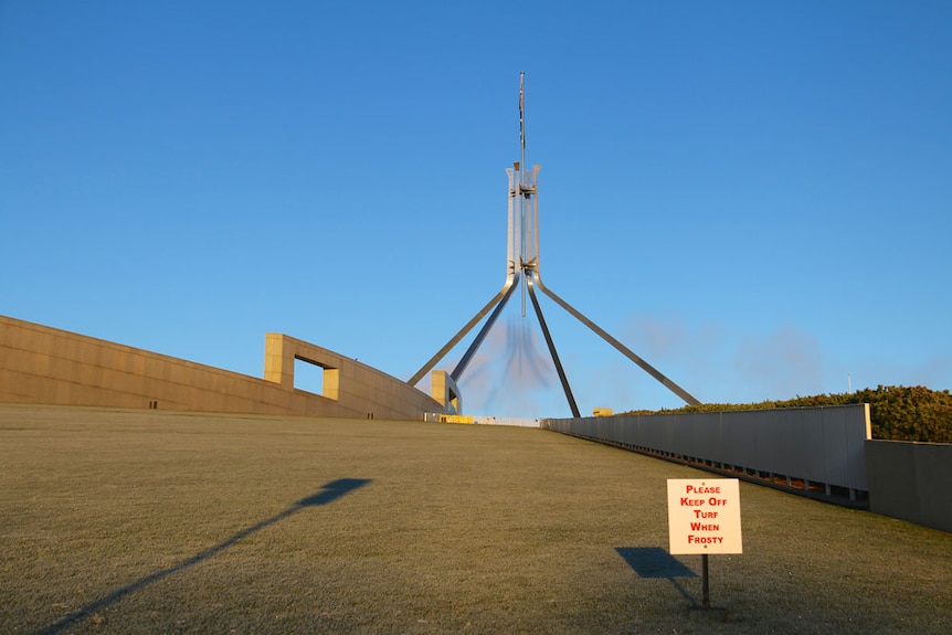 Flagpole shadow on Parliament House lawn.