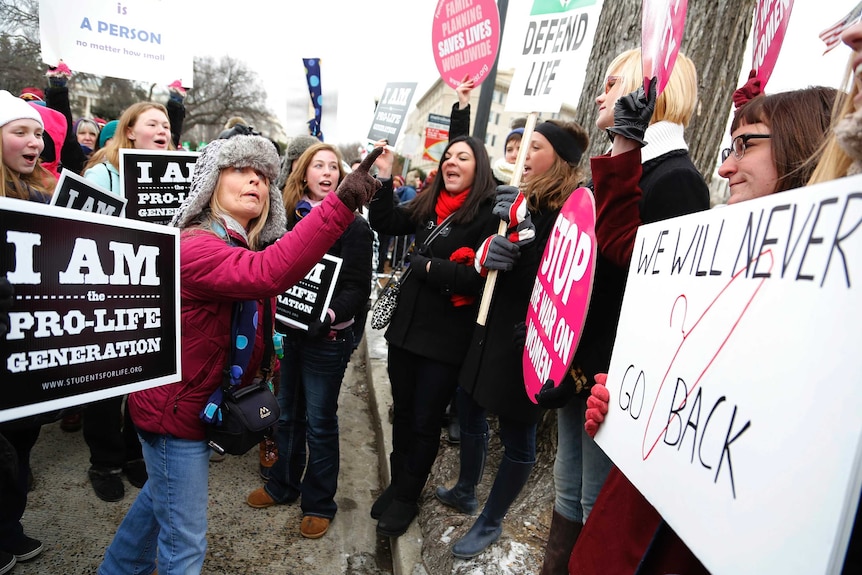 Anti-abortion marchers (L) argue with pro-abortion rights activists (R) in front of the US Supreme Court.