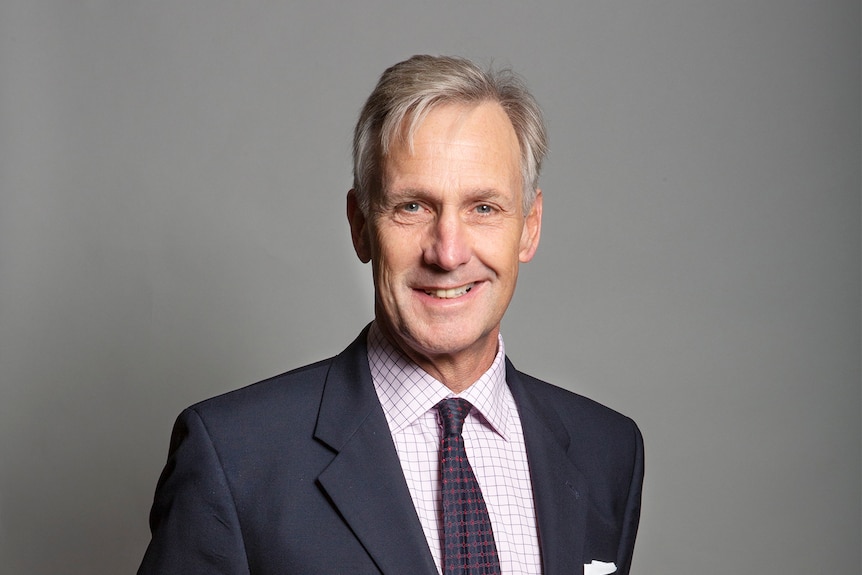 A portrait of a man with grey hair in a suit 