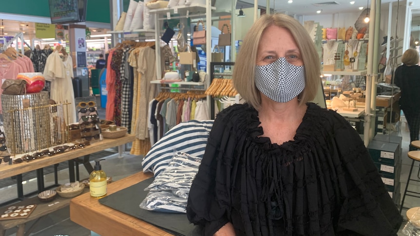 woman wearing mask in clothing store 