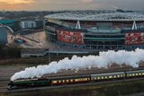Aerial view of the Flying Scotsman, steam billowing, as it passes the Emirates Stadium in London.