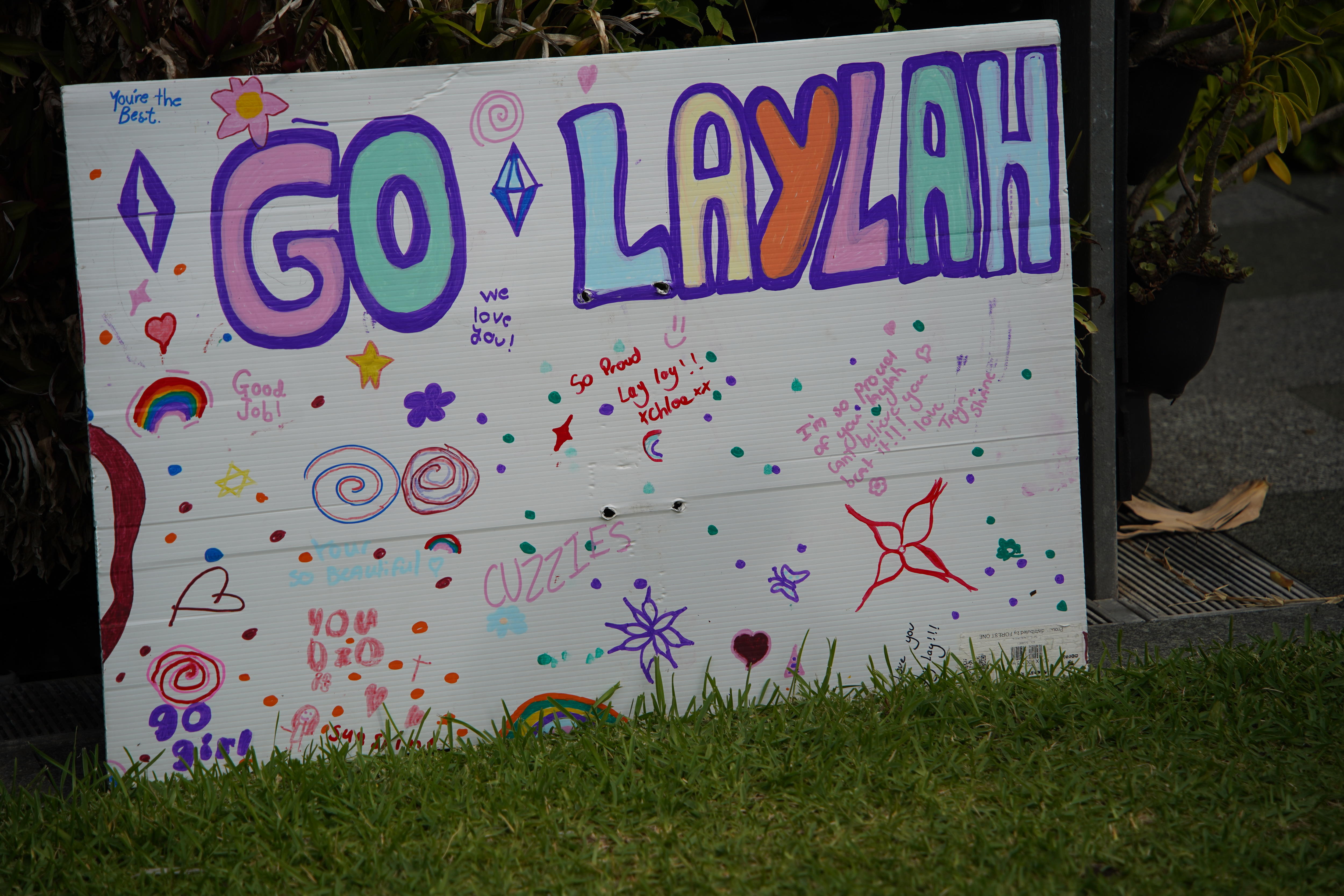 Un cartel colorido en un prado que dice 