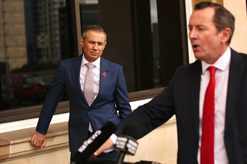 Roger Cook listens while Mark McGowan speaks at a media conference outside parliament in Perth, WA.