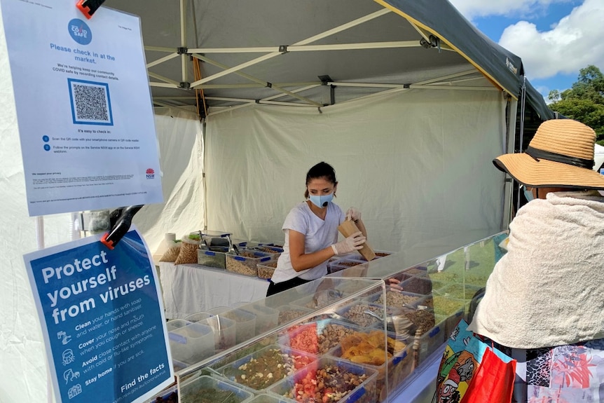 A woman behind a market stall.