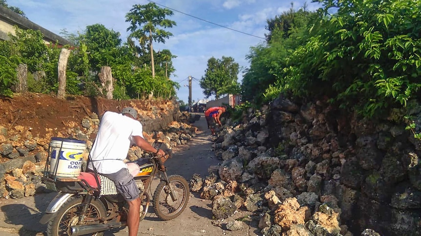 A resident looks at damages in Itbayat town in northern Philippines following the earthquakes.