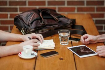 Two people sitting at a table with ipads