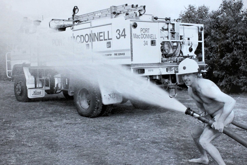 Port Macdonnell footballer Grant Fensom poses with a fire truck