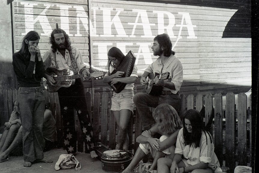 A black and white photo of a small group of men and women with various musical instruments
