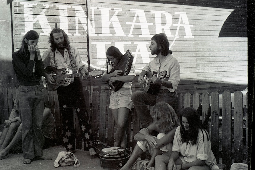 A black and white photo of a small group of men and women with various musical instruments