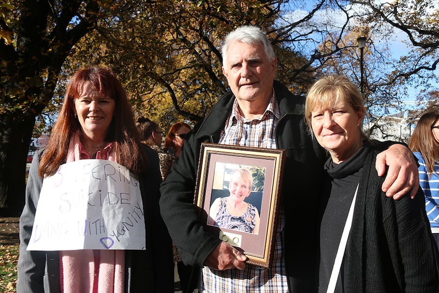 People hold a photo of a relative at a Hobart rally in support of euthanasia.