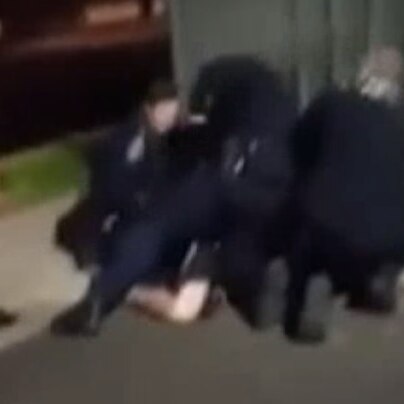 Still from footage showing an SA Police officer appearing to strike a man in custody in Adelaide's north.