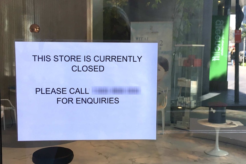 Sign on front window saying "This store is currently closed".