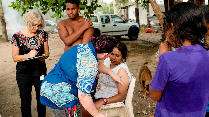 A woman gets vaccinated on the beach.