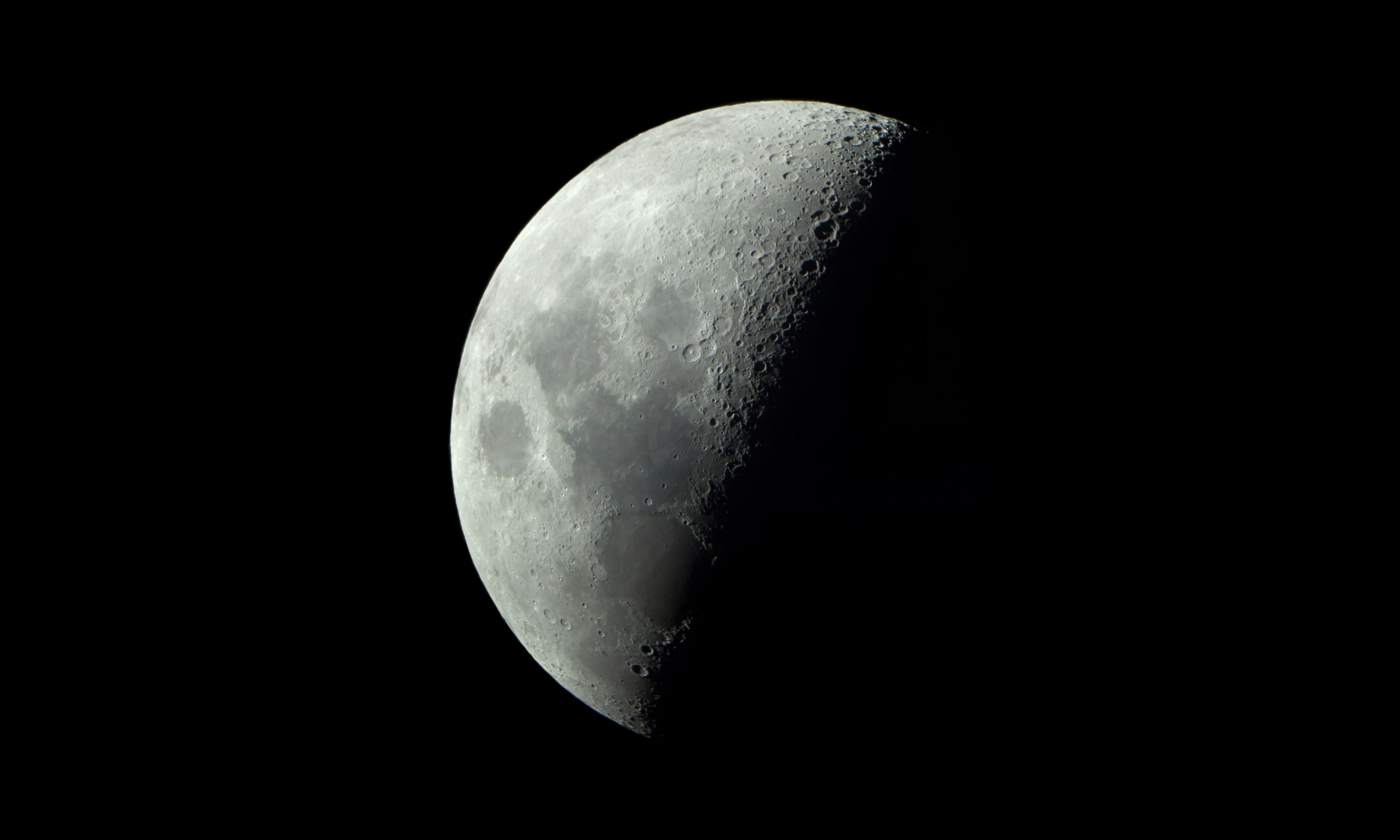Image of half a Moon against a black background.