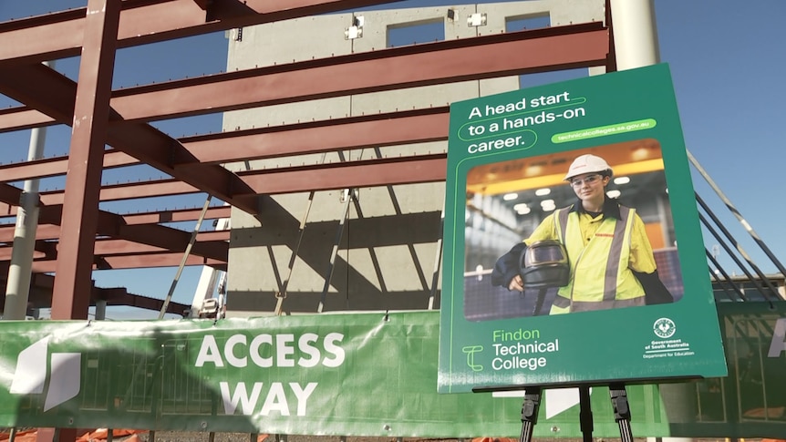 A green sign on a construction site saying 'a head start to a hands-on career'