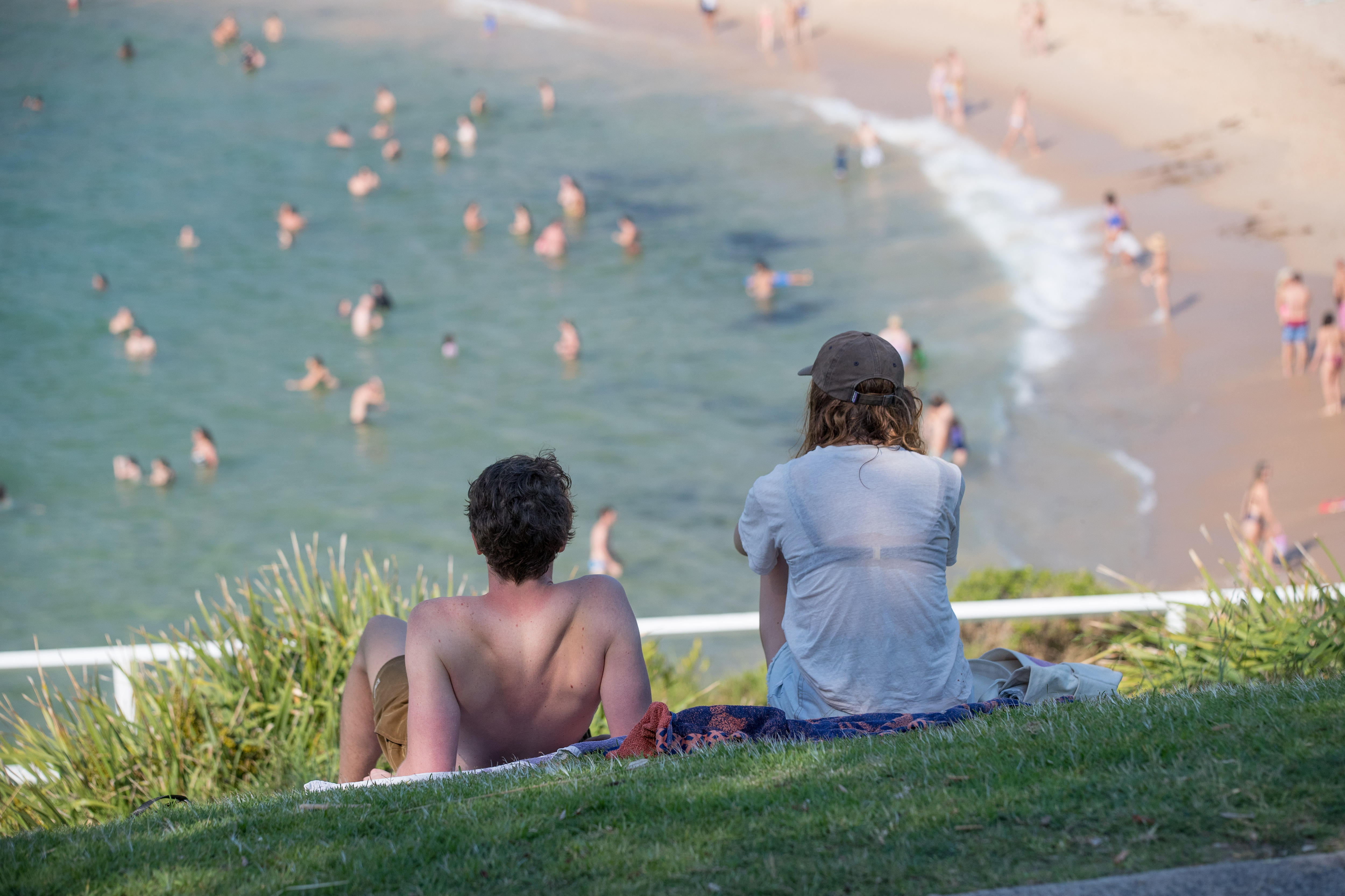 People at Coogee beach in Sydney sitting on the grass area overlooking the beach