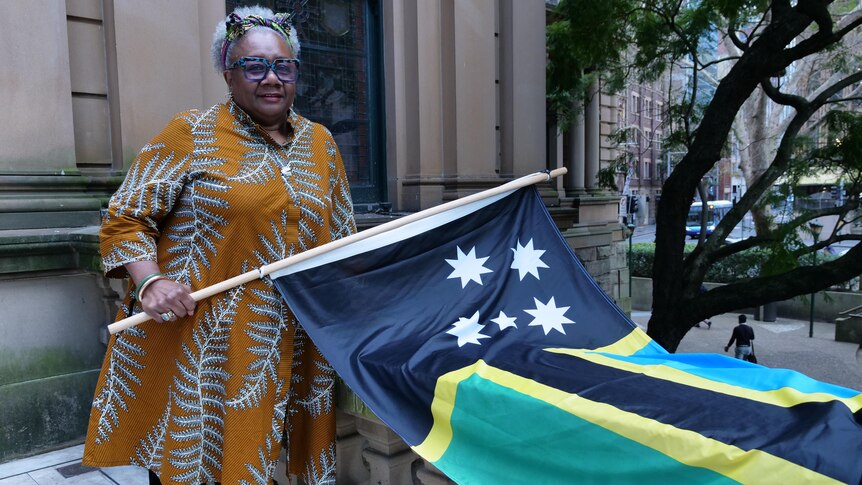 Cr Emelda Davis holding the Australian South Sea Islander flag