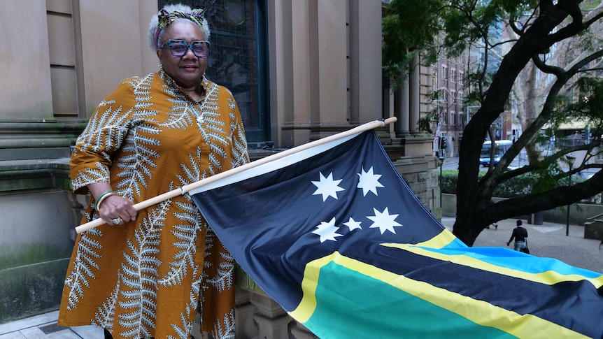 Cr Emelda Davis holding the Australian South Sea Islander flag