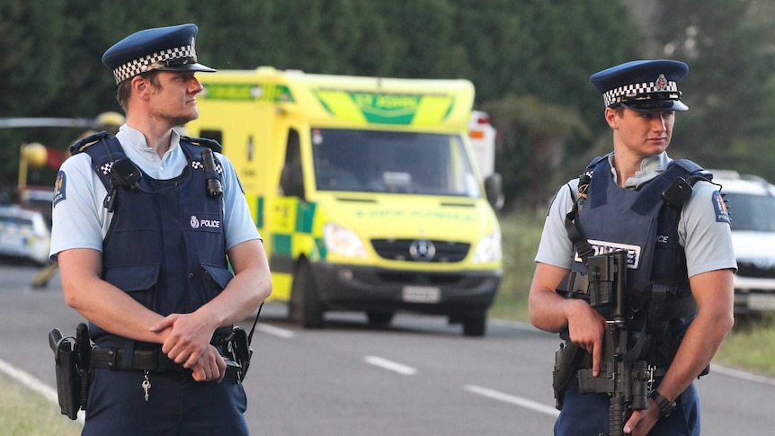 Two police officers stand guard at a roadblock where the shooting took place in rural New Zealand.