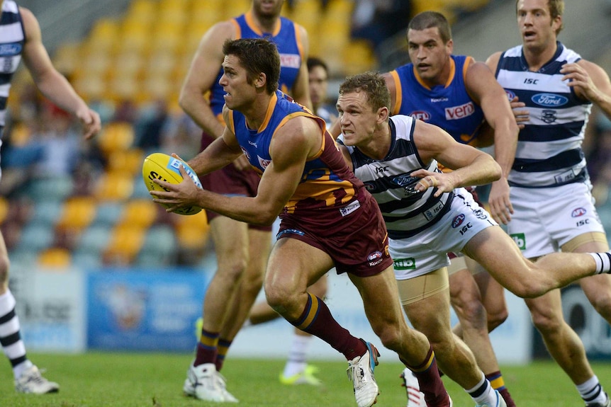 Simon Black looks up with the ball while breaking free of a pack of players.