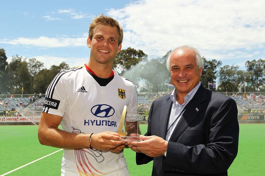 German hockey captain Moritz Fuerste (L) receives the FIH player of the year award.