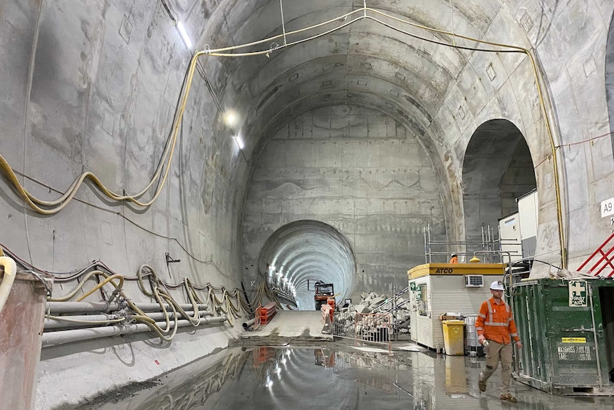 Martin Place metro rail station artistic shot of tunnel with worker walking towards camera.