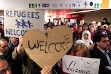 People hold signs welcoming migrants to Germany
