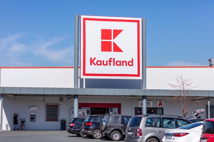 The outside of a supermarket with a large red and white sign that says Kaufland