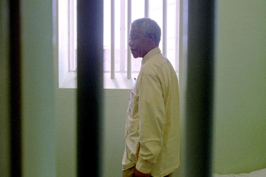 Nelson Mandela stands in the prison cell he occupied on Robben Island