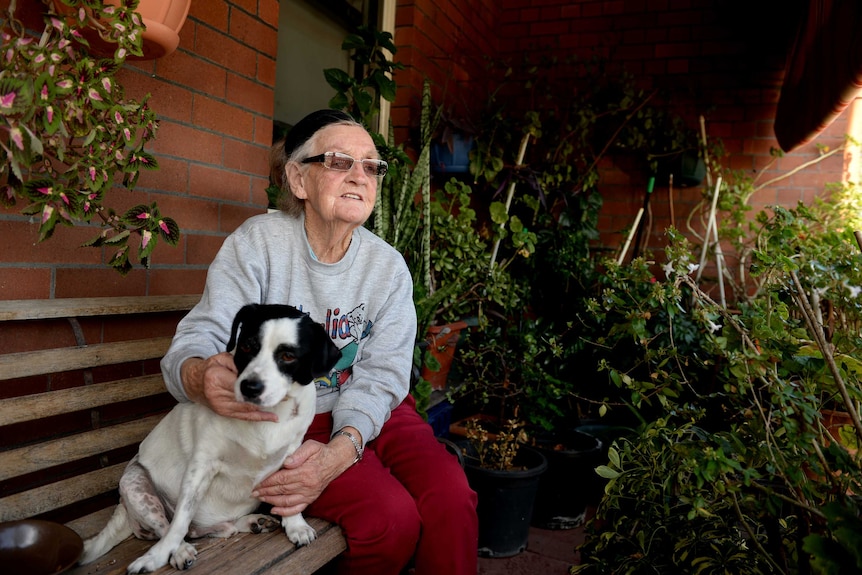 Public housing tenant Patricia Haub, 77, with her dog Randy, outside her home in Millers Point in Sydney.