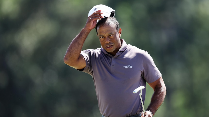 Golf star Tiger Woods takes his cap off his head on the final hole of his round at the Masters.