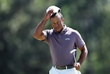 Golf star Tiger Woods takes his cap off his head on the final hole of his round at the Masters.